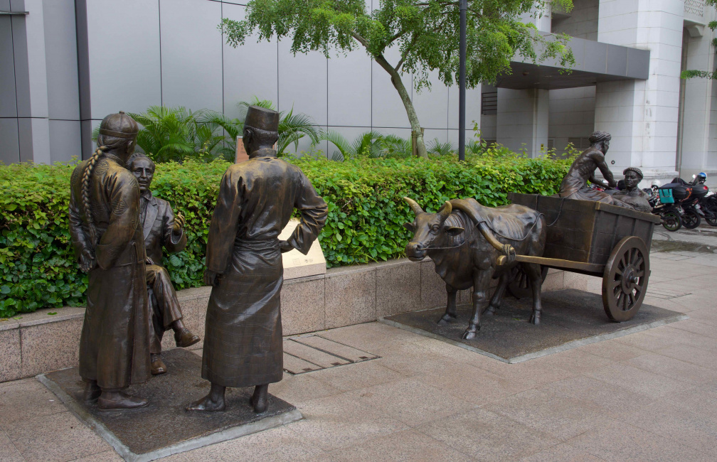 The most interesting thing about this statue of merchants in old Singapore... 