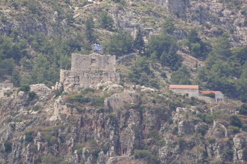 Greek flag flying above an old castle on the Greek Island of Kastelorizo (as seen from Turkish waters)